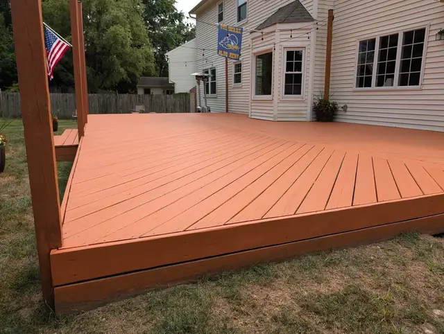 The same deck refinished in a warm solid-color stain, clean and uniform